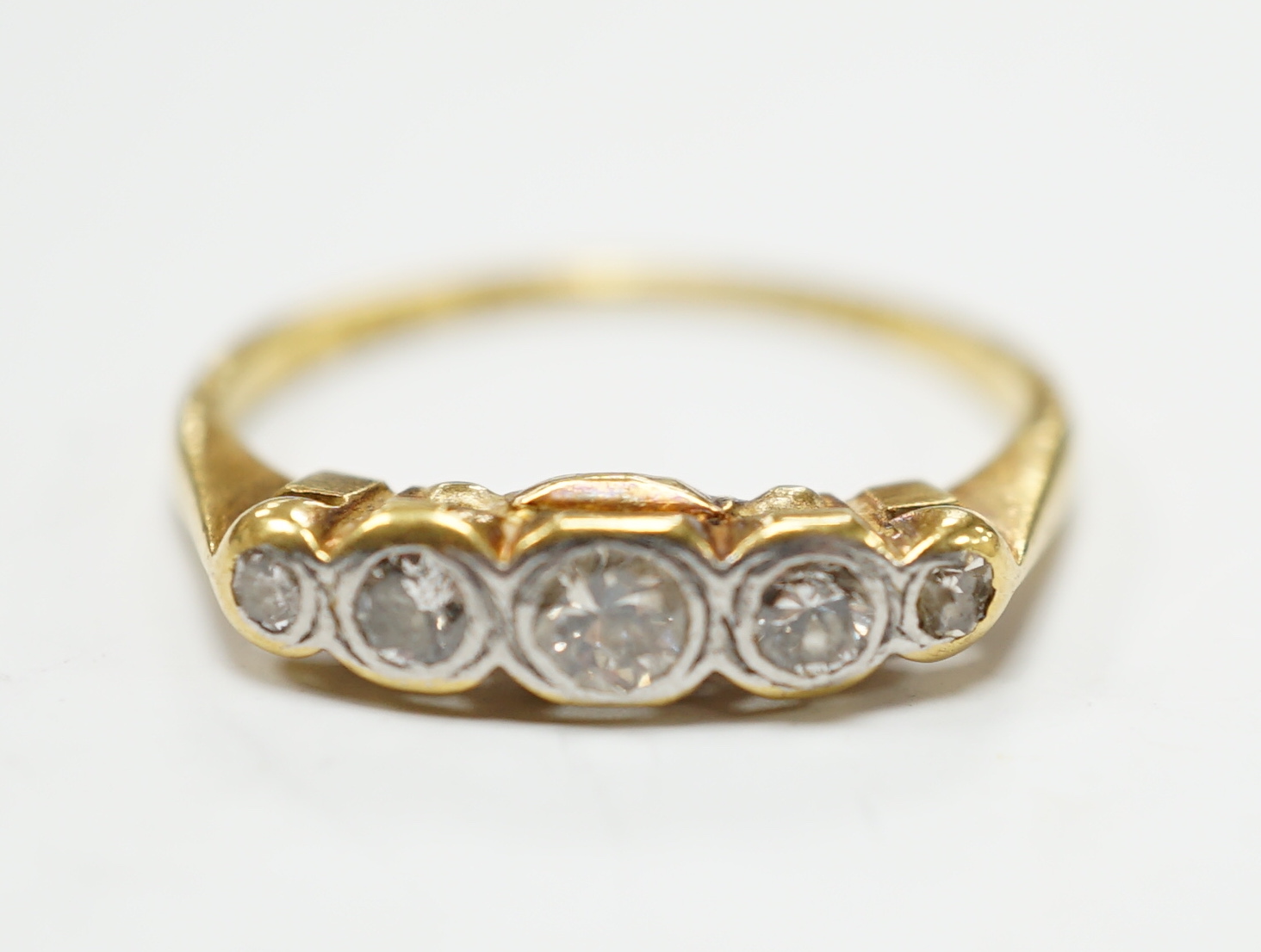 An 18ct, plat and graduated collet set five stone diamond half hoop ring, size P, gross weight 3.1 grams.